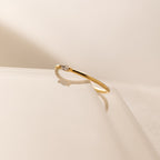 The Marquise Birthstone Ring, featuring a delicate design and a small diamond, rests on a glossy surface with a soft shadow, showcasing its elegant charm.