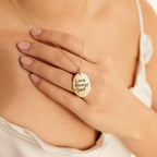 A woman wears the Oval Fingerprint Necklace, featuring a gold pendant etched with “Love Always Dad,” an elegant and personalized memorial jewelry piece resting on her chest.