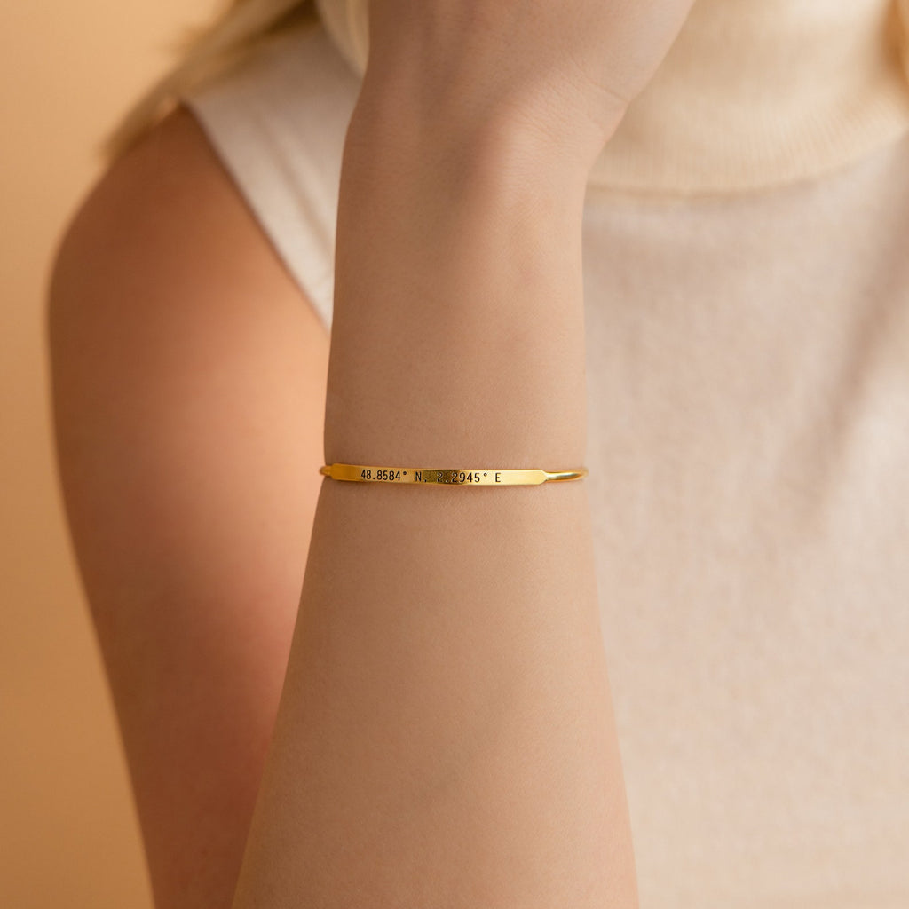 Custom Message Cuff engraved in gold, shown on a woman's wrist with a sleeveless cream top—an ideal personalized gift for someone special.