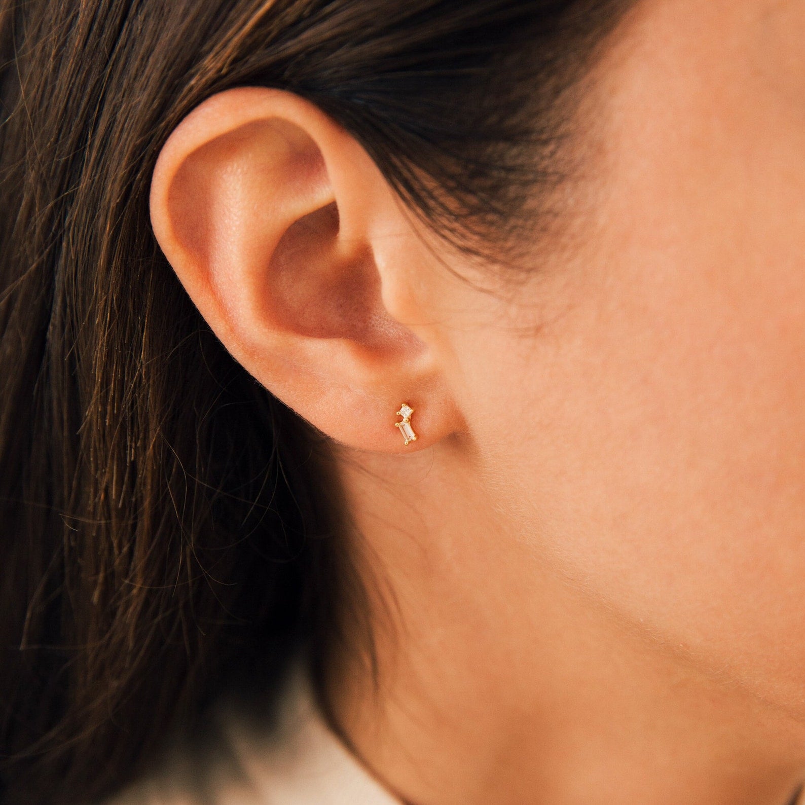 Close-up of a woman’s ear wearing Blair Baguette Diamond Drop Studs—ideal for those who appreciate minimalist, elegant earrings.