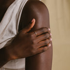 Wearing a Marquise Birthstone Ring, a person gently rests their hand on their upper arm while dressed in a sleeveless white top.