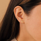 Close-up of a woman's ear wearing Emilia Butterfly Studs, delicate earrings that add a trendy touch to any outfit.