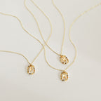 A selection of gold necklaces with letters, including a personalized initial necklace and the colorful Rainbow Initial Necklace.