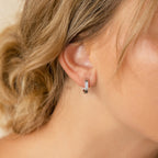 Close-up of a woman's ear wearing Ribbed Link Hoops; her wavy blonde hair is pulled back.