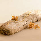 The Roxy Paperclip Chain Bracelet features a bold, chunky design and rests on driftwood with dried flowers, set against a soft beige background.