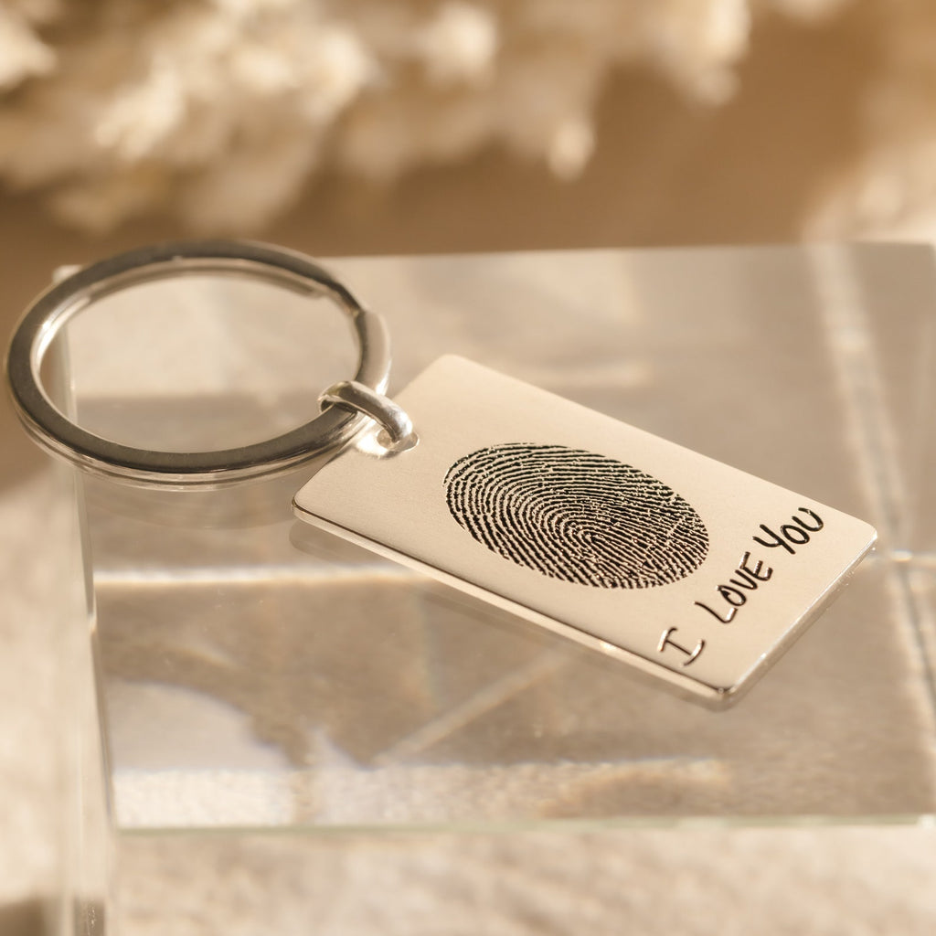 The Fingerprint Rectangle Keychain features a custom fingerprint engraving and the words "I LOVE YOU," creating a personalized keepsake that is both meaningful and unique.