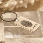 The Fingerprint Rectangle Keychain features a custom fingerprint engraving and the words "I LOVE YOU," creating a personalized keepsake that is both meaningful and unique.