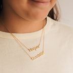 Close-up of a child wearing two Maine Kid's Name Necklaces, each personalized with "Harper" and "Charlotte," highlighting stylish, customized kids jewelry.