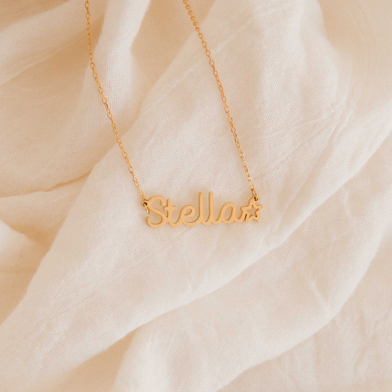 The Maine Kid's Name Necklace features "Stella" and a star charm on cream-colored fabric—a delightful personalized piece from our kids jewelry collection.