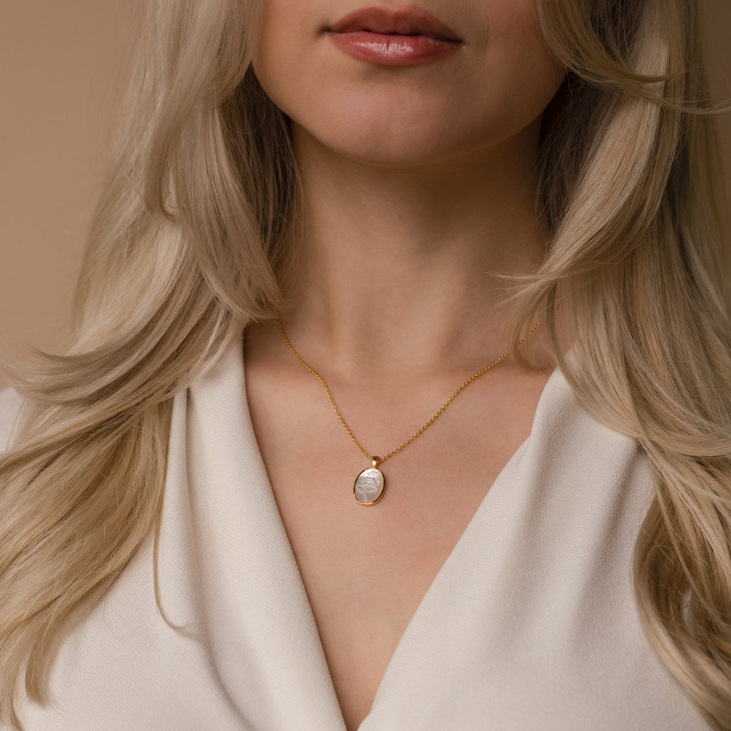 Woman with long blonde hair wearing a Vintage Rose Necklace and a cream blouse—an elegant style that's perfect as a Mother's Day gift.