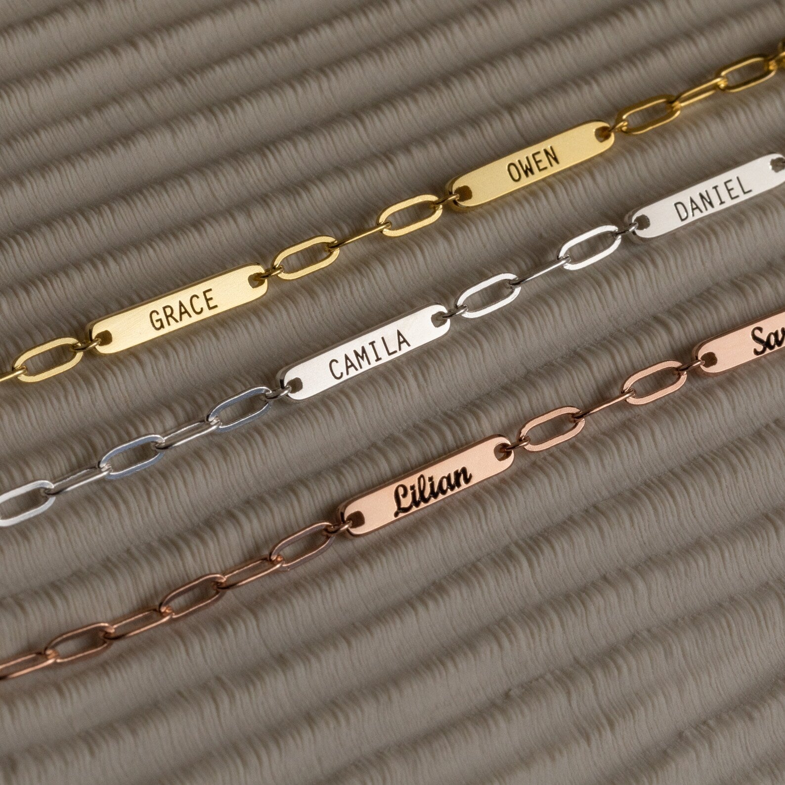 Three metal chain bracelets with nameplates—Grace, Owen, Camila, Daniel, Lilian, and Sam—ideal for stacking or pairing with a Mini Name Bar Necklace to create your unique style.