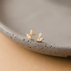 Flora Marquise Studs—gold stud earrings featuring three marquise-shaped crystals, shown on a speckled ceramic dish. Perfect minimalist earrings for everyday elegance.