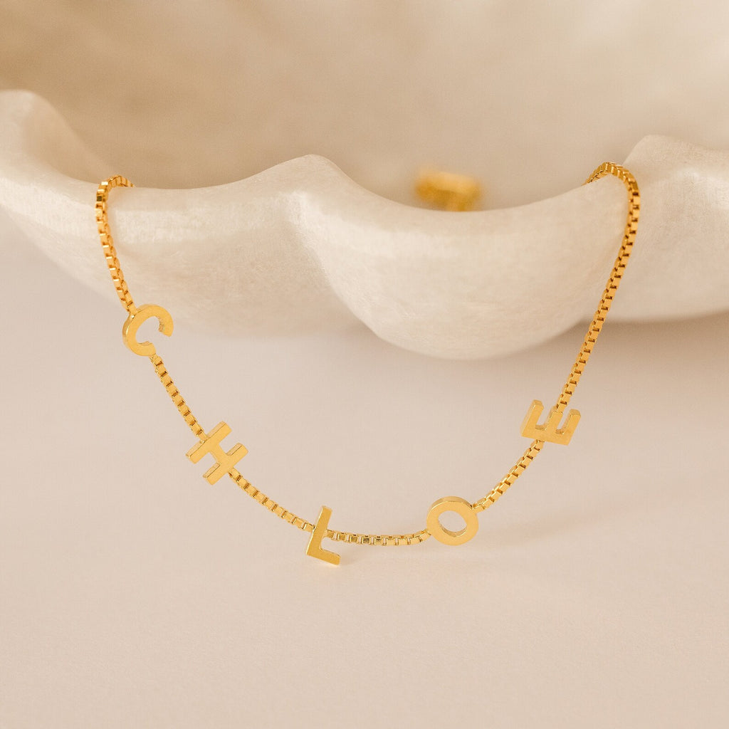 Alex Slider Bracelet in Box Chain, elegantly displayed on a white clam-shaped dish—a stunning piece of customizable jewelry and a thoughtful, unique gift.