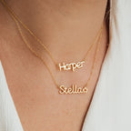 Two Maine Kid's Name Necklaces personalized with "Harper" and "Stella" are worn over a white textured top, highlighting stylish children’s jewelry.