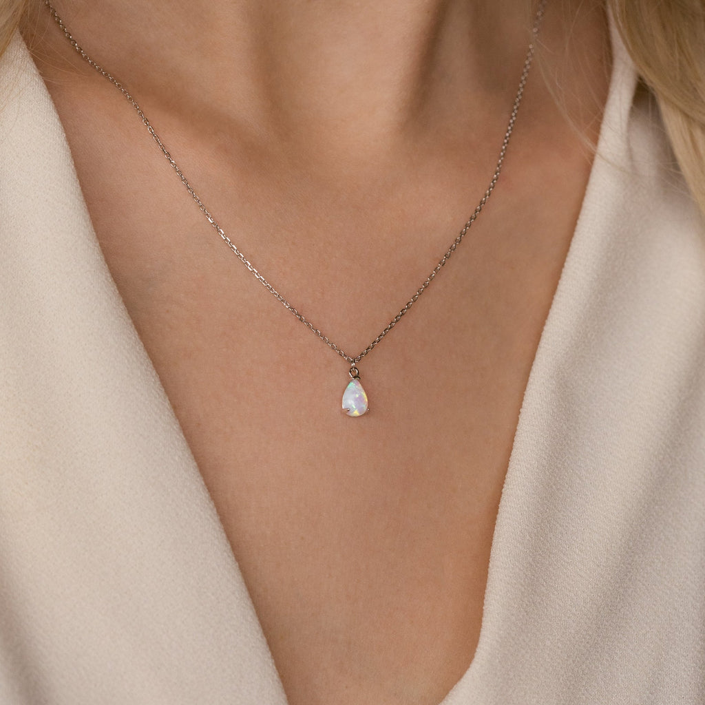 Close-up of a woman's neck wearing the Tabitha Opal Drop Necklace—a delicate silver chain with a teardrop opal charm, perfect as a romantic gift.