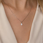 Close-up of a woman's neck wearing the Tabitha Opal Drop Necklace—a delicate silver chain with a teardrop opal charm, perfect as a romantic gift.