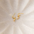 Opal Moon Mini Hoops, gold crescent-shaped earrings shown on a light textured surface—perfect for adding a touch of elegance to your earring stack.