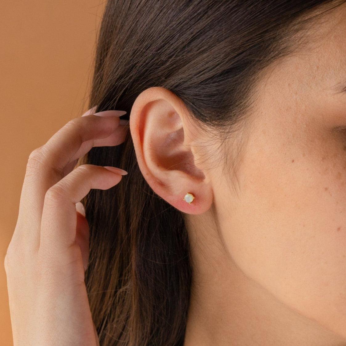 A close-up of a woman's ear wearing Booker Large Birthstone Studs—an elegant and thoughtful jewelry gift.
