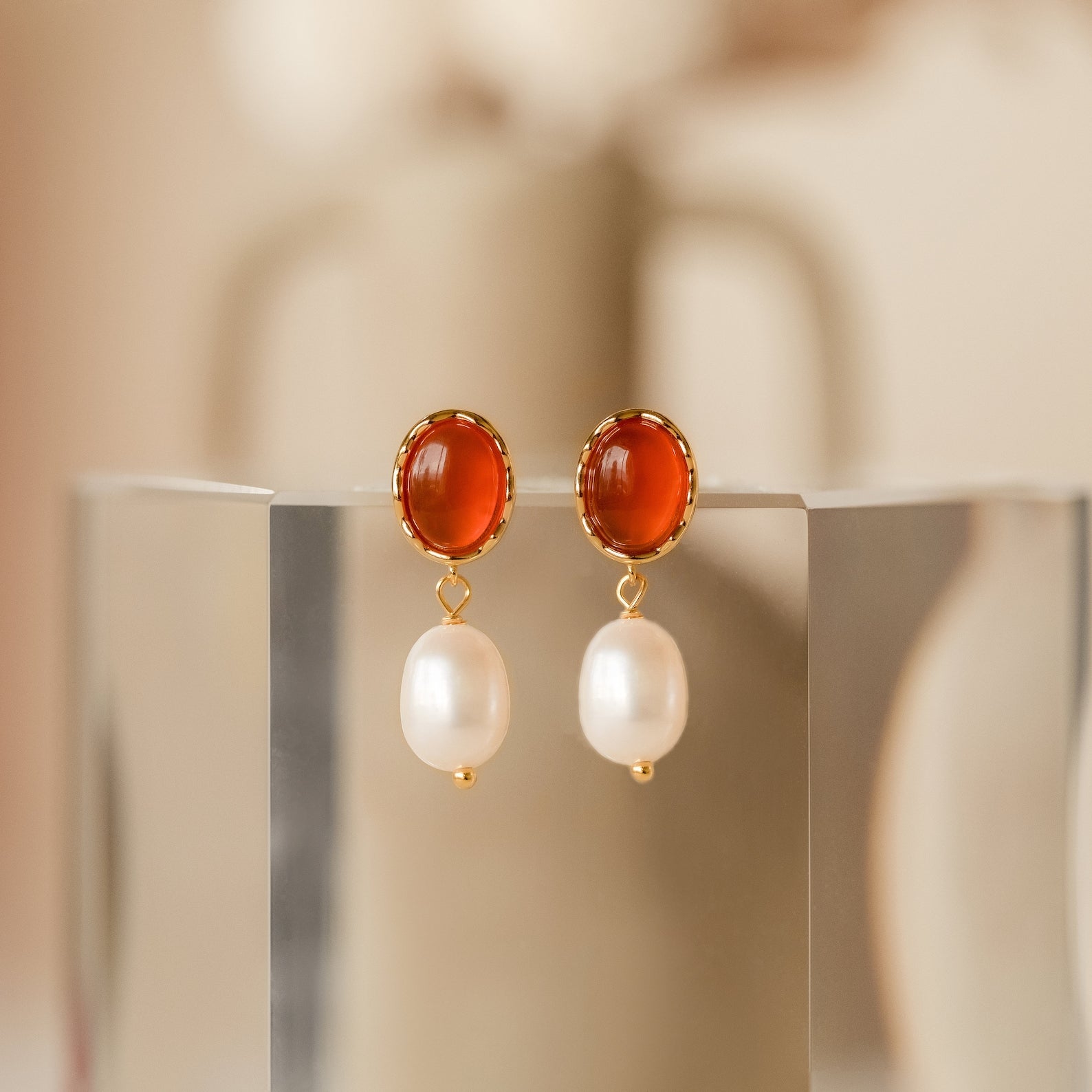 The Carnelian Pearl Earrings feature gold pearl dangles with round amber studs, bringing earthy elegance and a warm, carnelian-inspired touch to your jewelry collection.