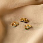 The Opal Inlay Huggies Set features gold and blue huggie hoop earrings, some with vibrant opal colors.