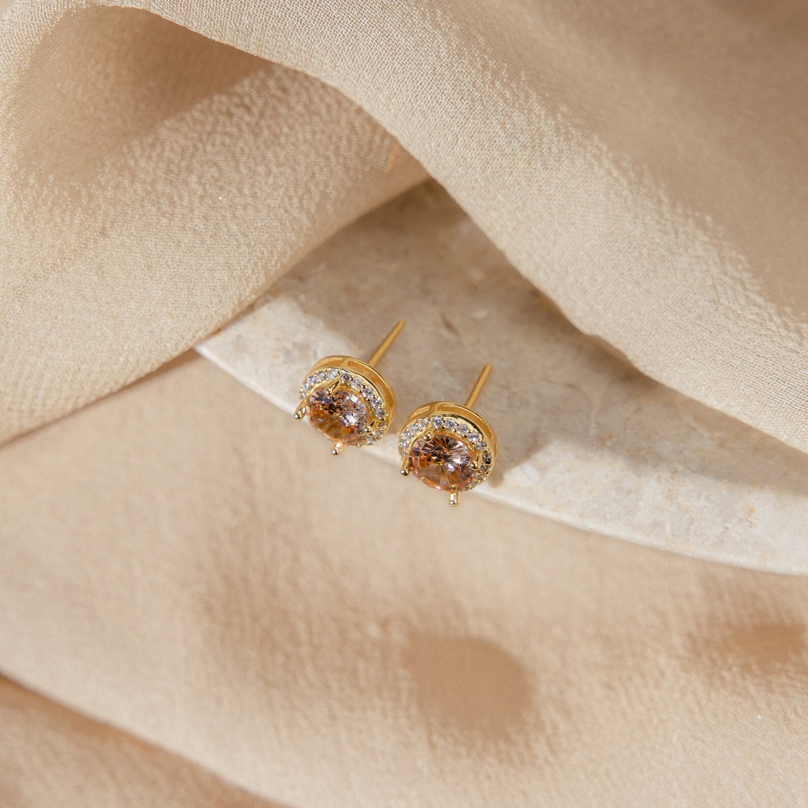 The Halo Birthstone Studs feature sparkling diamonds and a gold halo design, ideal for adding a touch of elegance to any look.