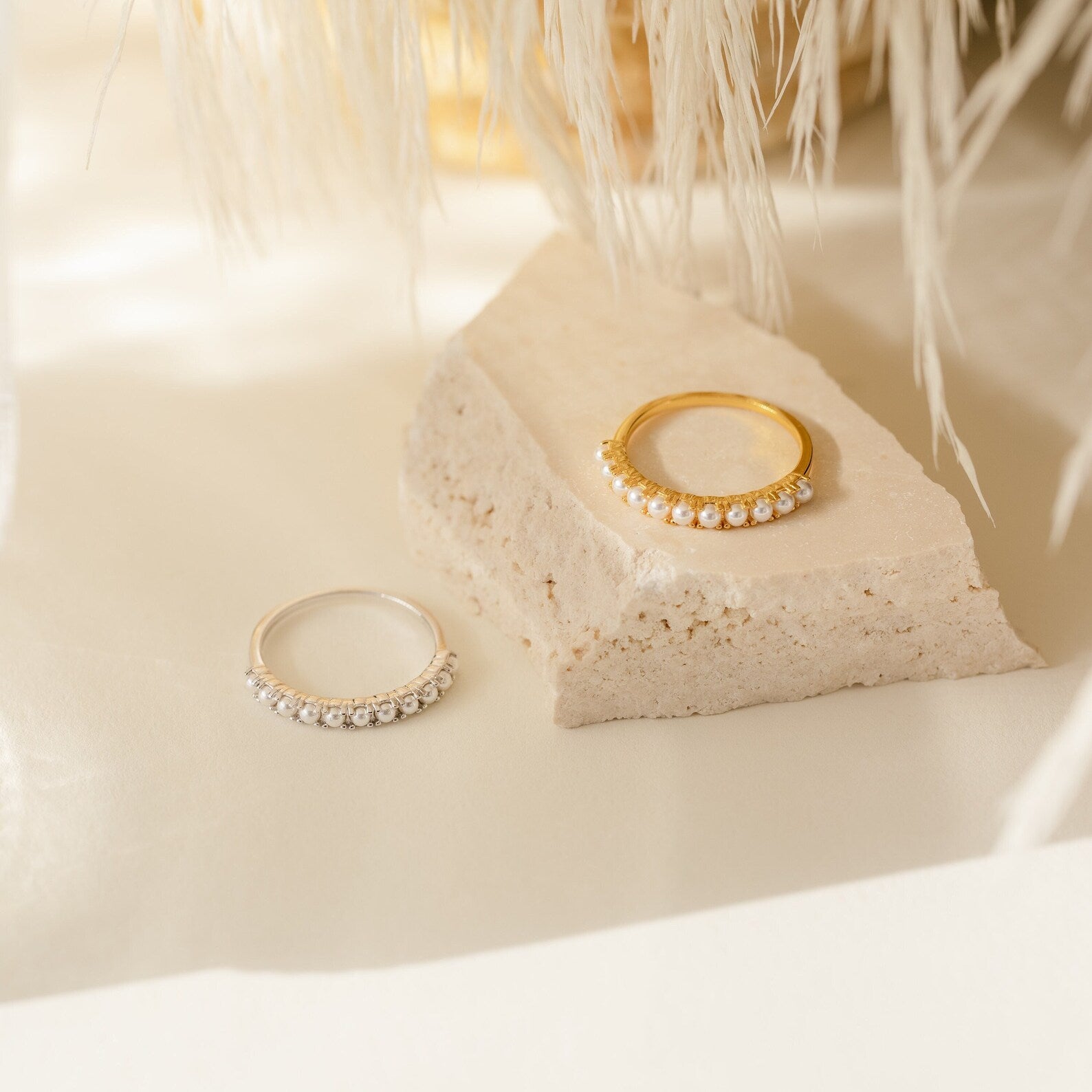 The Crescent Pearl Ring is displayed on a textured stone surface—perfect minimalist jewelry for a chic handmade stacking ring look.