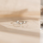 The Layla Opal Diamond Ring features a delicate minimal design, sparkling with boho chic style as its opal and diamond accents shimmer on a light, reflective surface.