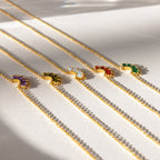 Five Marquise Birthstone Necklaces with colorful gemstone pendants are arranged in a neat row on a white surface.