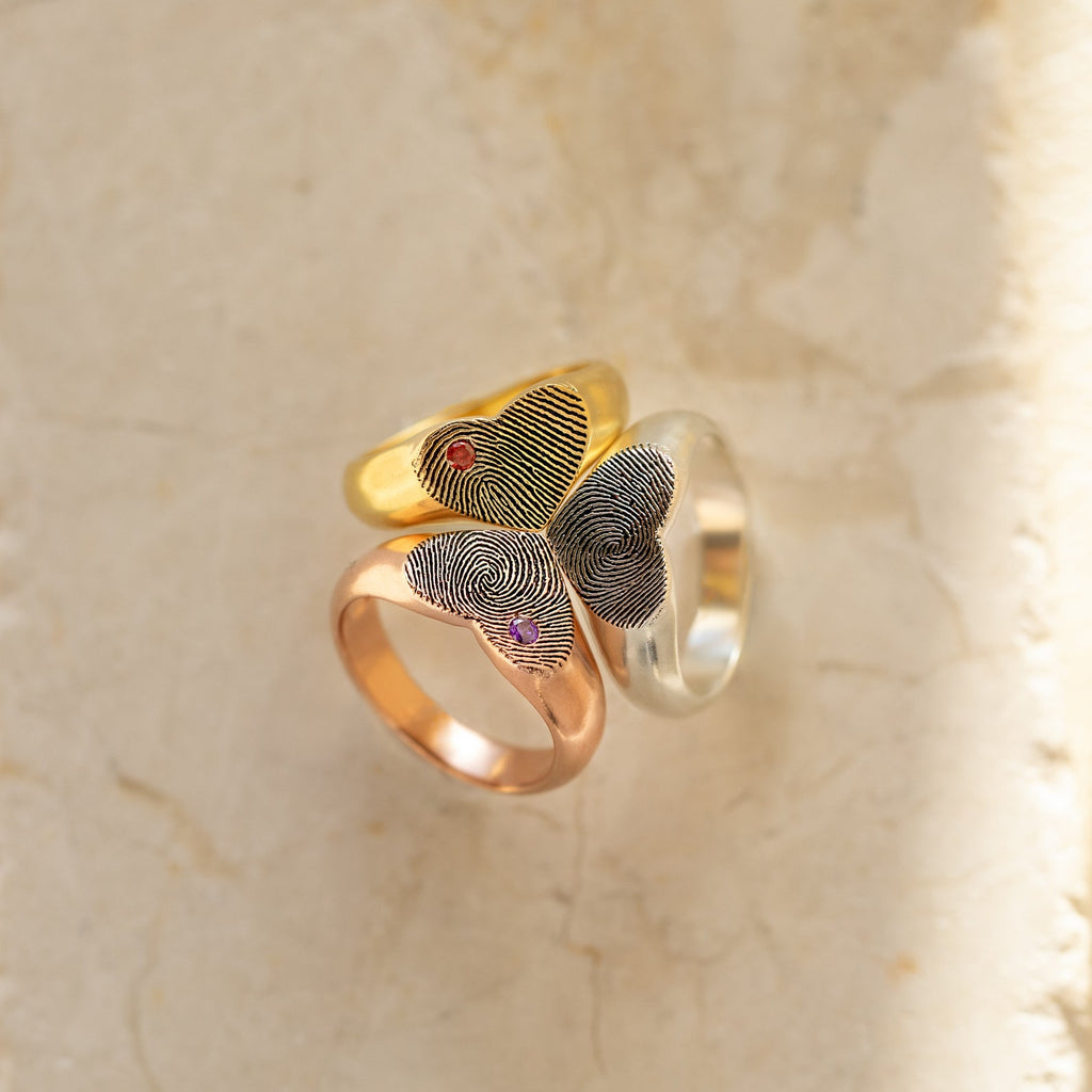 The Fingerprint Heart Signet Ring comes in gold, rose gold, and silver, each with your unique fingerprint and a gemstone—an unforgettable gift for mom.