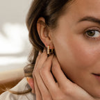 Close-up of a woman touching her ear, wearing the Rayne Pearl Link Earrings—minimalist gold hoops adorned with freshwater pearls.