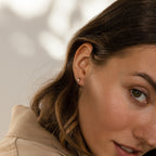Woman with light brown hair wearing Raindrop Pearl Onyx Studs, shown in close-up against a neutral background.