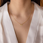 A woman wearing a Marquise Birthstone Necklace and a white V-neck blouse.