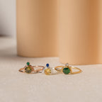 The Duo Vintage Birthstone Ring, featuring gold and silver bands with gemstones, is displayed on a soft beige background—an elegant personalized mom ring ideal for Mother's Day or as a thoughtful new mom gift.