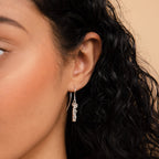 A close up of a woman's ear adorned with Old English Dangling Name Earrings.