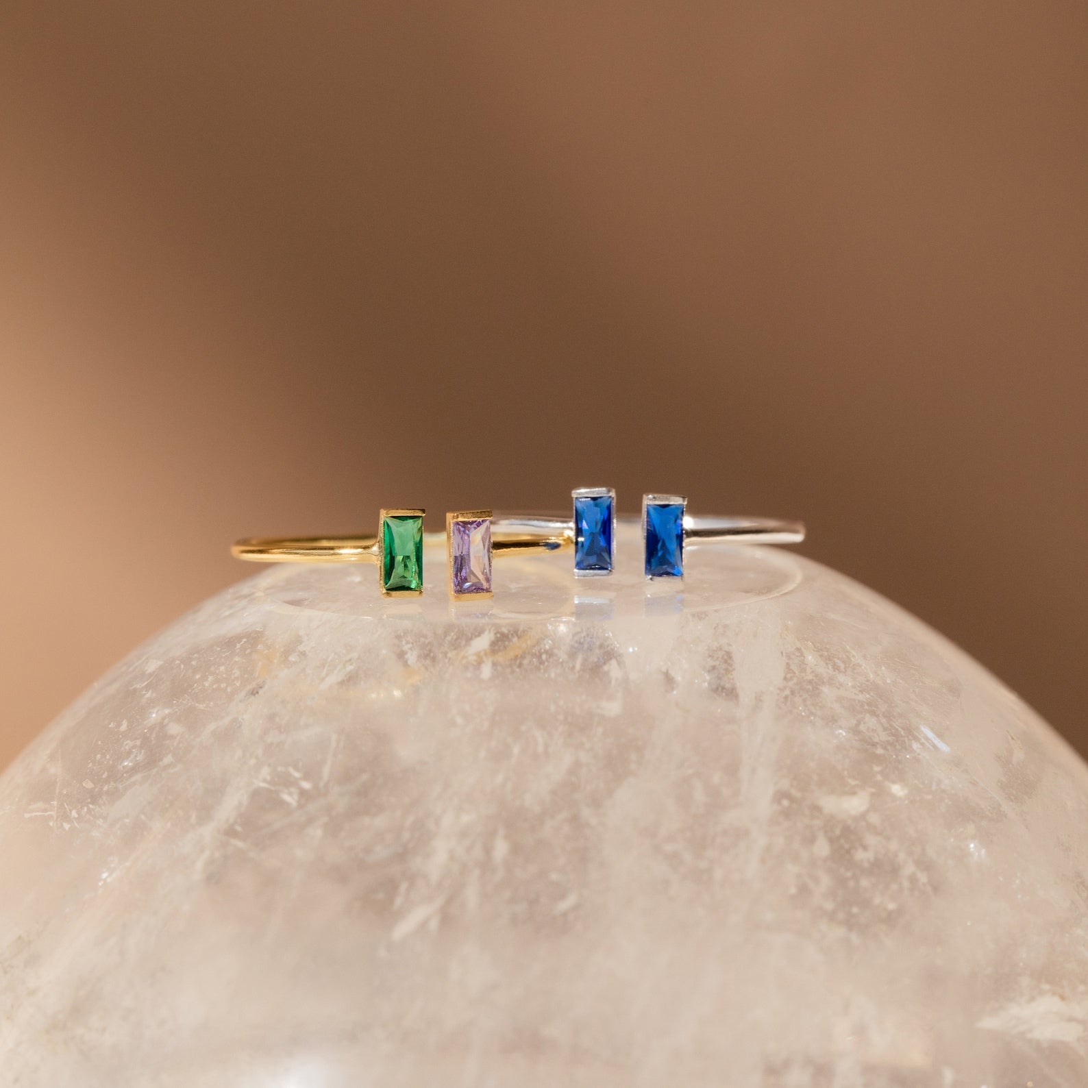 The Duo Vertical Baguette Ring features two elegant rectangular gemstones set vertically—an ideal choice for a personalized gift or custom birthstone ring, beautifully displayed on a translucent, textured surface.