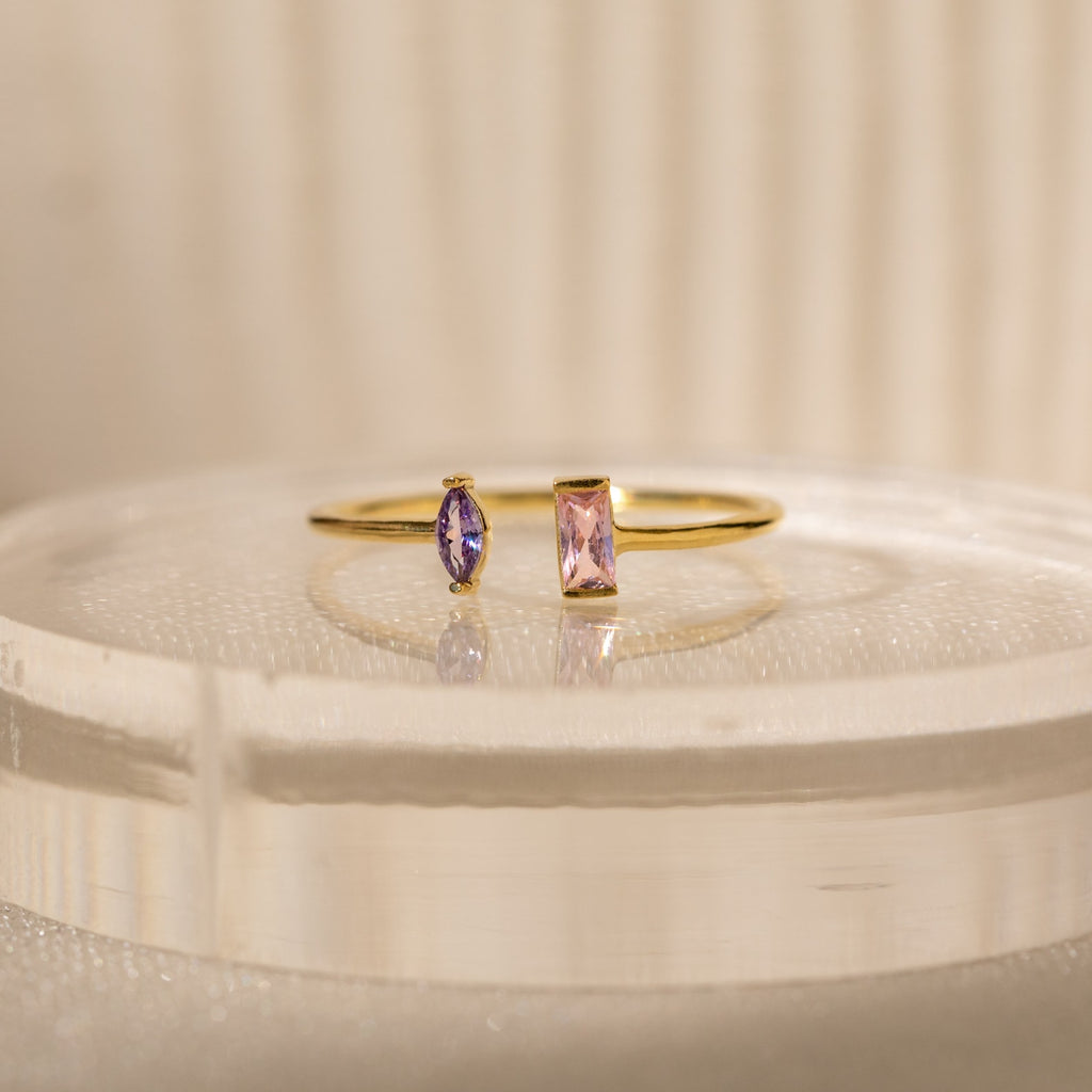 The Duo Marquise Baguette Ring showcases a purple marquise and a pink baguette stone on a translucent band. Experience the allure of handcrafted jewelry with this personalized gemstone ring.