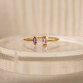 The Duo Marquise Baguette Ring showcases a purple marquise and a pink baguette stone on a translucent band. Experience the allure of handcrafted jewelry with this personalized gemstone ring.