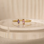 The Duo Marquise Baguette Ring showcases a purple marquise and a pink baguette stone on a translucent band. Experience the allure of handcrafted jewelry with this personalized gemstone ring.