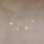 The Old English Letter Name Necklace features dangling letter charms spelling "mama" in a decorative font on a thin gold chain—an ideal minimalist jewelry piece.