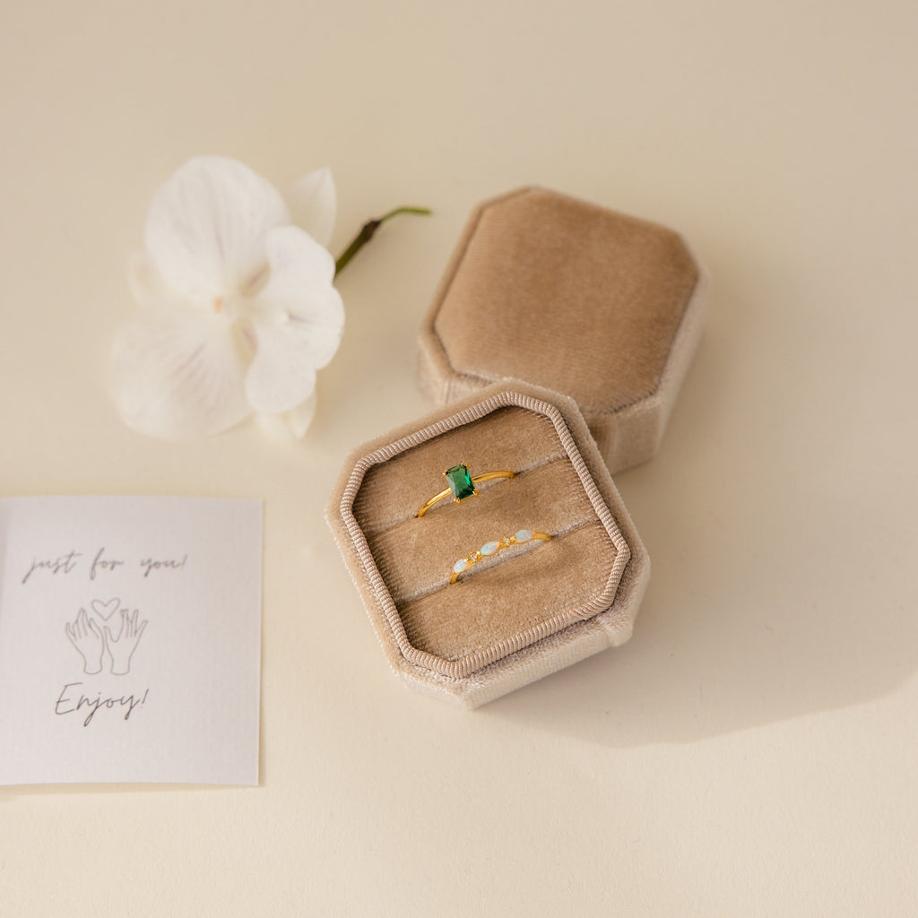 The 2 Slot Velvet Ring Box in elegant beige holds two gold rings, displayed with an orchid flower and a note reading "just for you! Enjoy!" nearby.