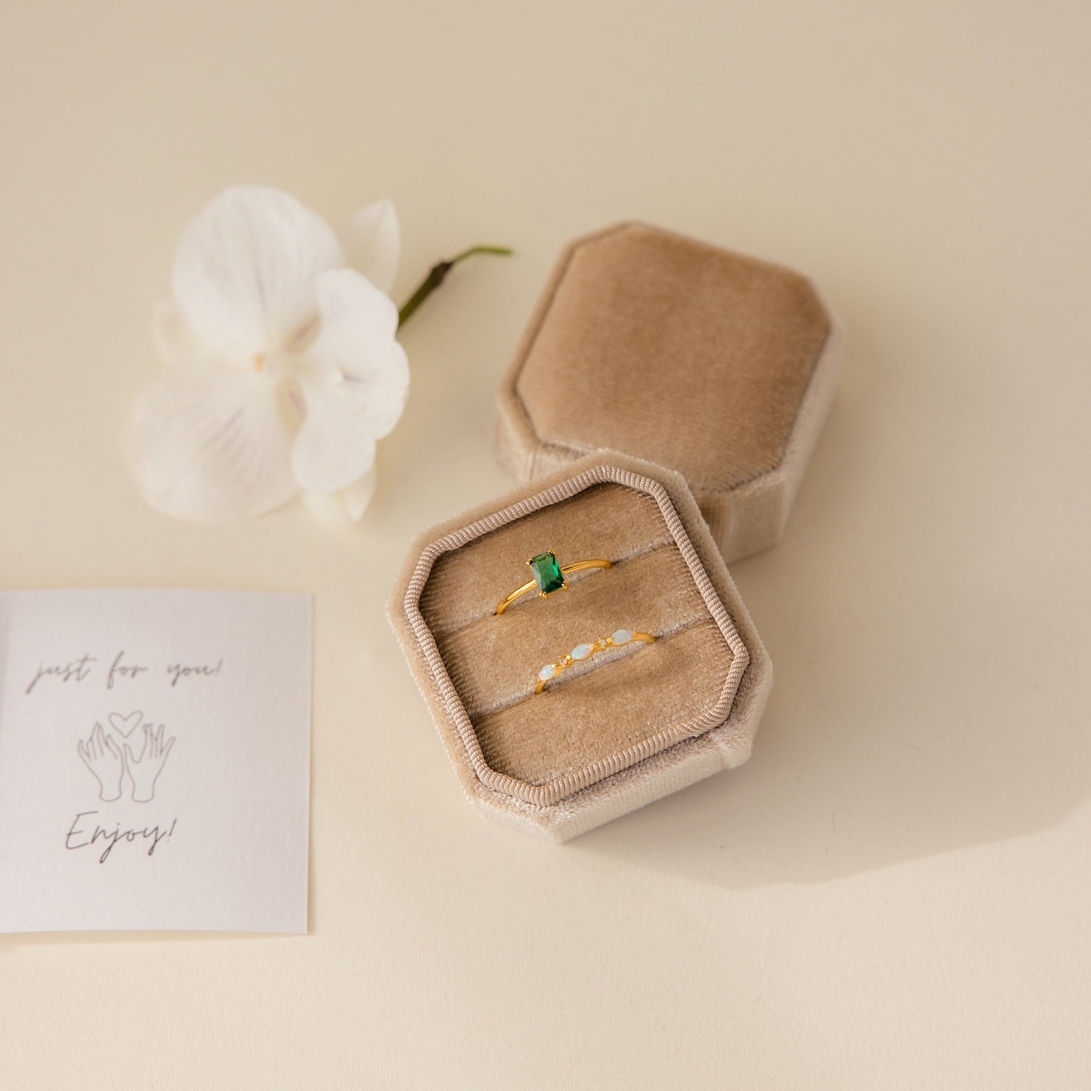 The 2 Slot Velvet Ring Box in elegant beige holds two gold rings, displayed with an orchid flower and a note reading "just for you! Enjoy!" nearby.