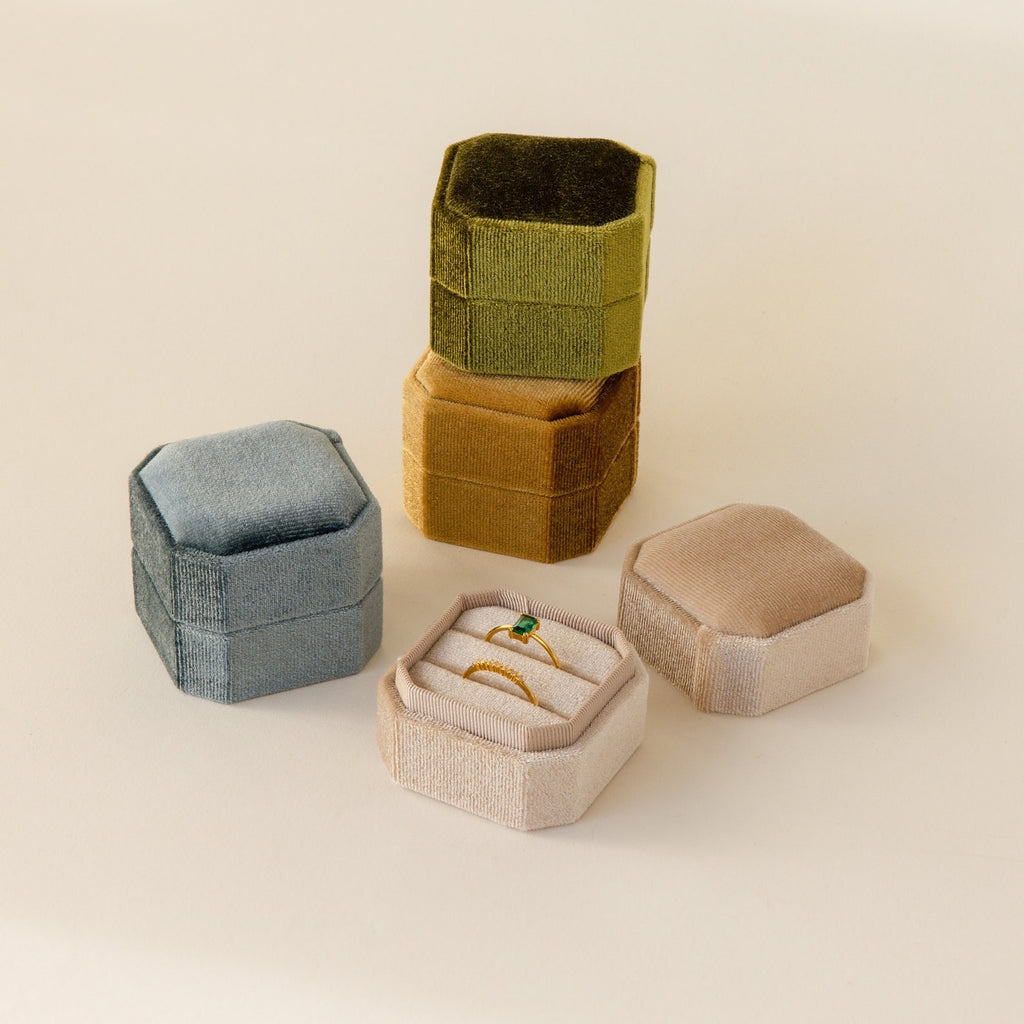 Four elegant 2 Slot Velvet Ring Boxes in green, gold, blue, and beige; the beige box is open to reveal its two-slot holder displaying sparkling rings.