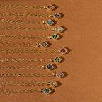Ten Birthstone Diamond Pendant Necklaces are arranged in a neat diagonal line on a brown background.