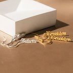 Four Old English Dangling Name Earrings in silver and gold, customized with “Juliette” and “Brooklyn,” displayed on a tan surface—ideal as a personalized gift or for those wanting handmade drop earrings.