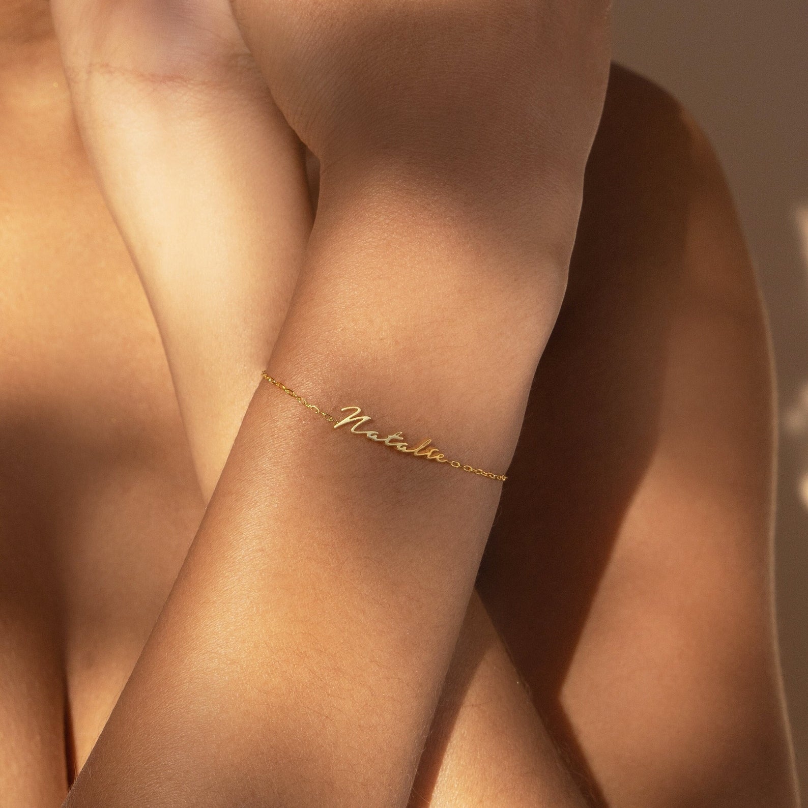 The Venice Tiny Name Bracelet featuring "Natalie" glows softly on a wrist in natural light—ideal for minimal jewelry lovers.