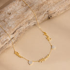 Grace Name Heart Necklace features a gold chain with personalized cursive name and Mom charms, plus two small heart pendants—an elegant custom necklace for any occasion.