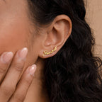 A Grace Name Earring spelling "summer" shines on a woman's ear as she gently touches her cheek—the perfect personalized earring and custom gift.