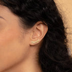 Close-up of Old English Name Earrings in gold spelling "Morgan," worn on an ear with curly dark hair—ideal personalized jewelry for a unique, custom gift.
