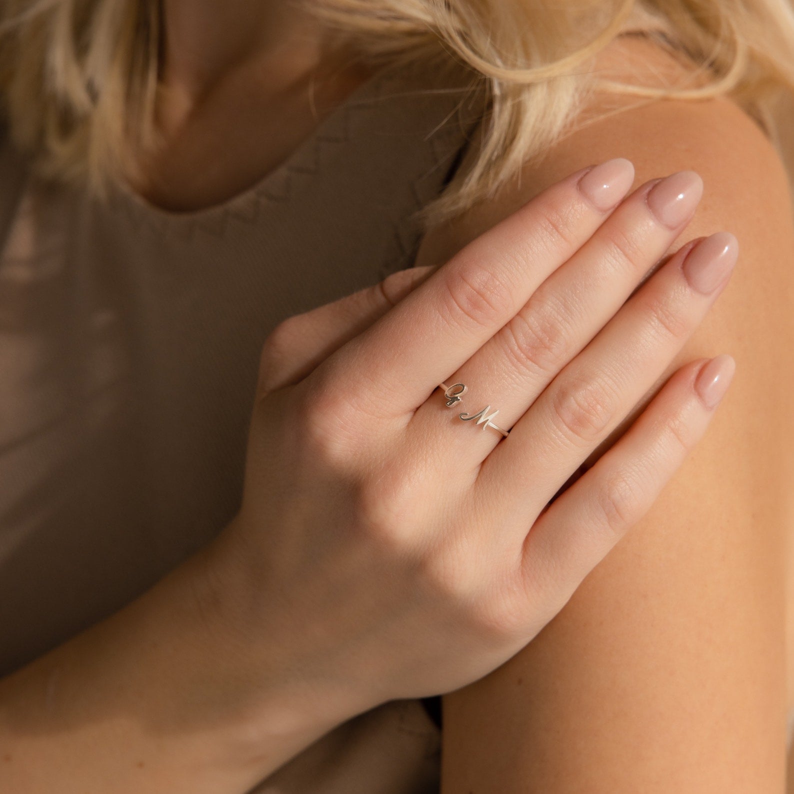 A woman's hand with nude nails wears the Hallie Duo Initial Ring, a delicate silver accessory that’s perfect for personalized jewelry.
