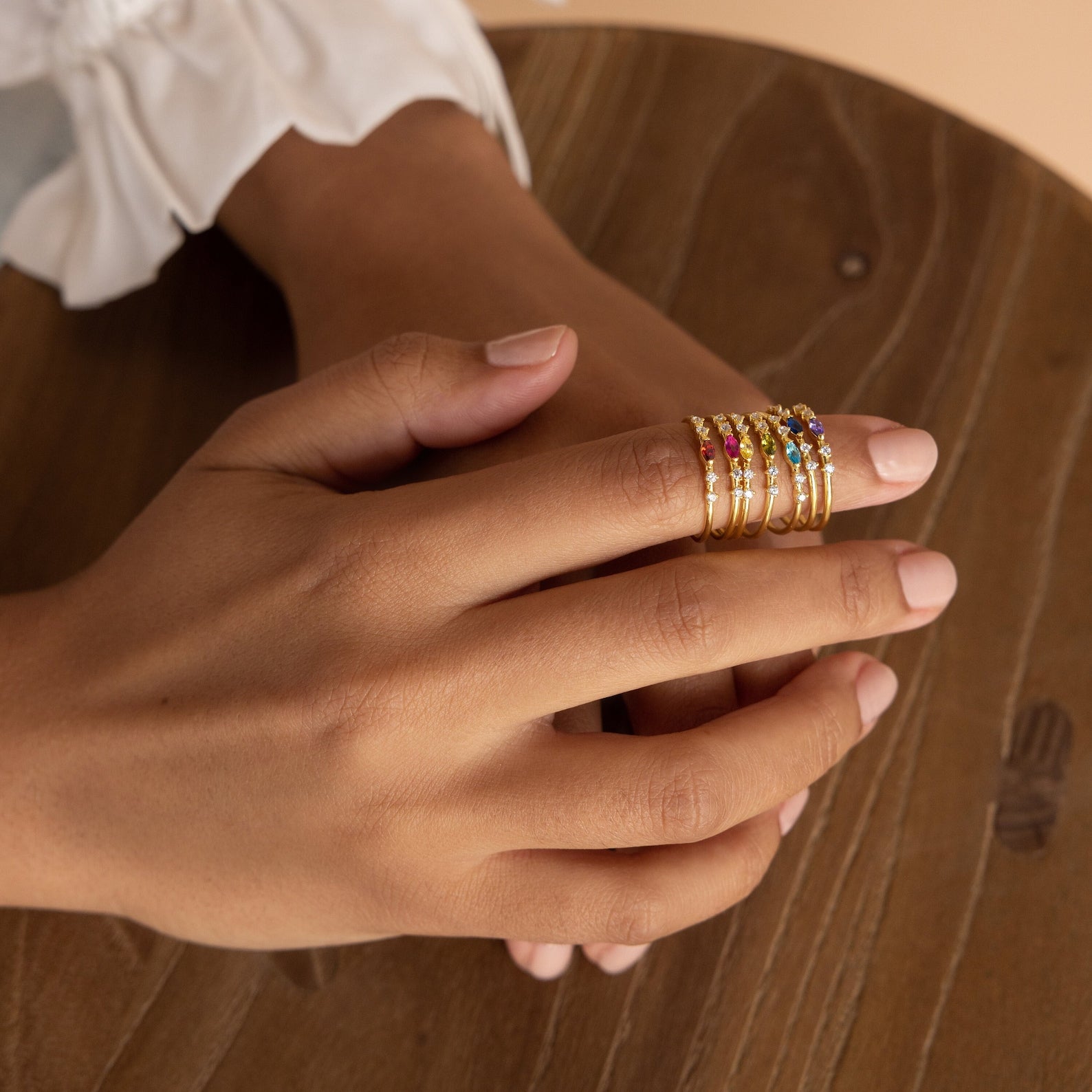 A hand adorned with the Space Marquise Birthstone Ring, its crystal stones catching the light.